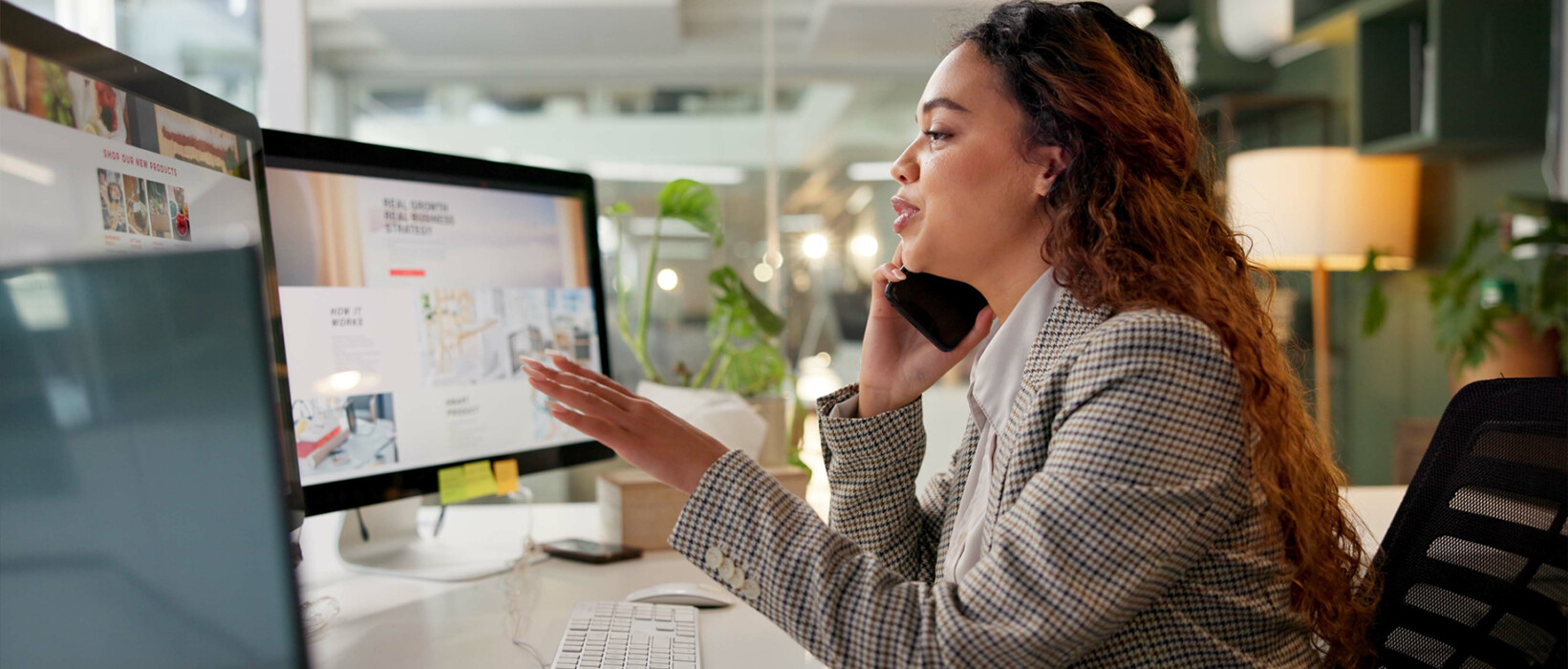 Business professional talking on the phone while reviewing digital advertising materials.