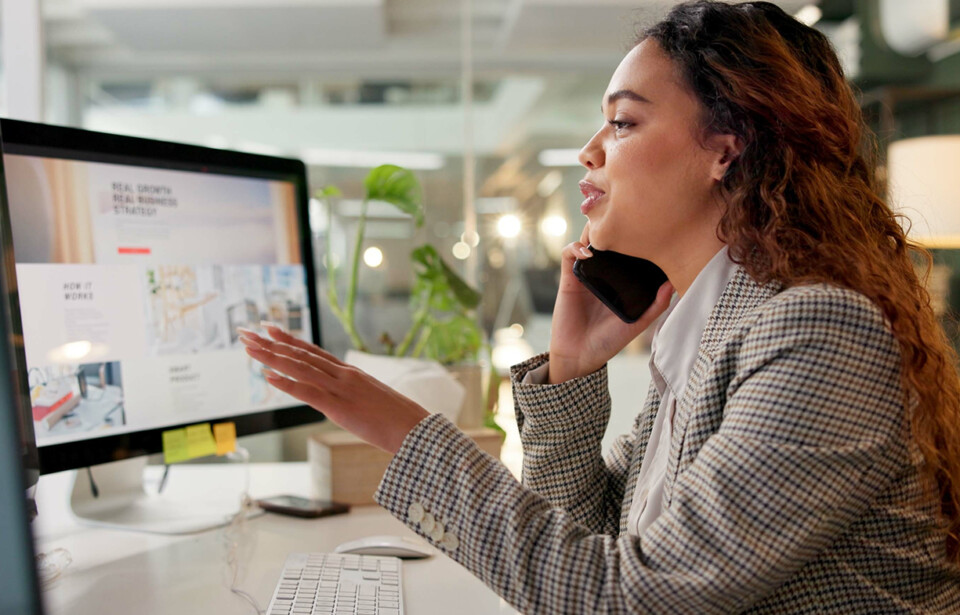 Business professional talking on the phone while reviewing digital advertising materials.