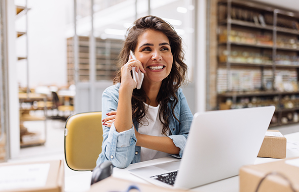 Business professional on the phone while working at a laptop.