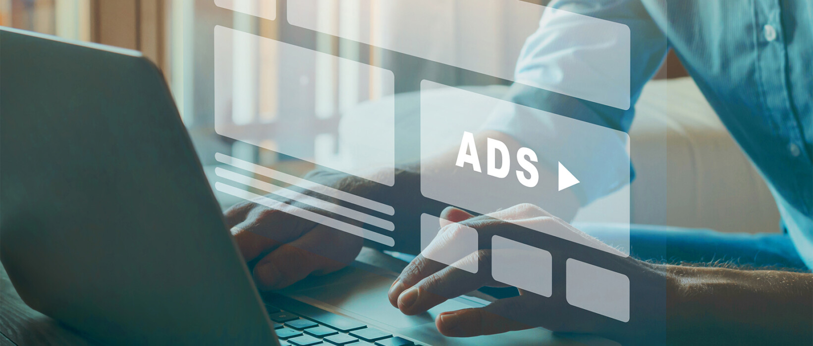 Person using a laptop with digital ad graphics on screen.