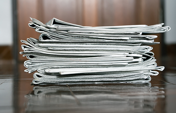 Stack of newspapers on a table.