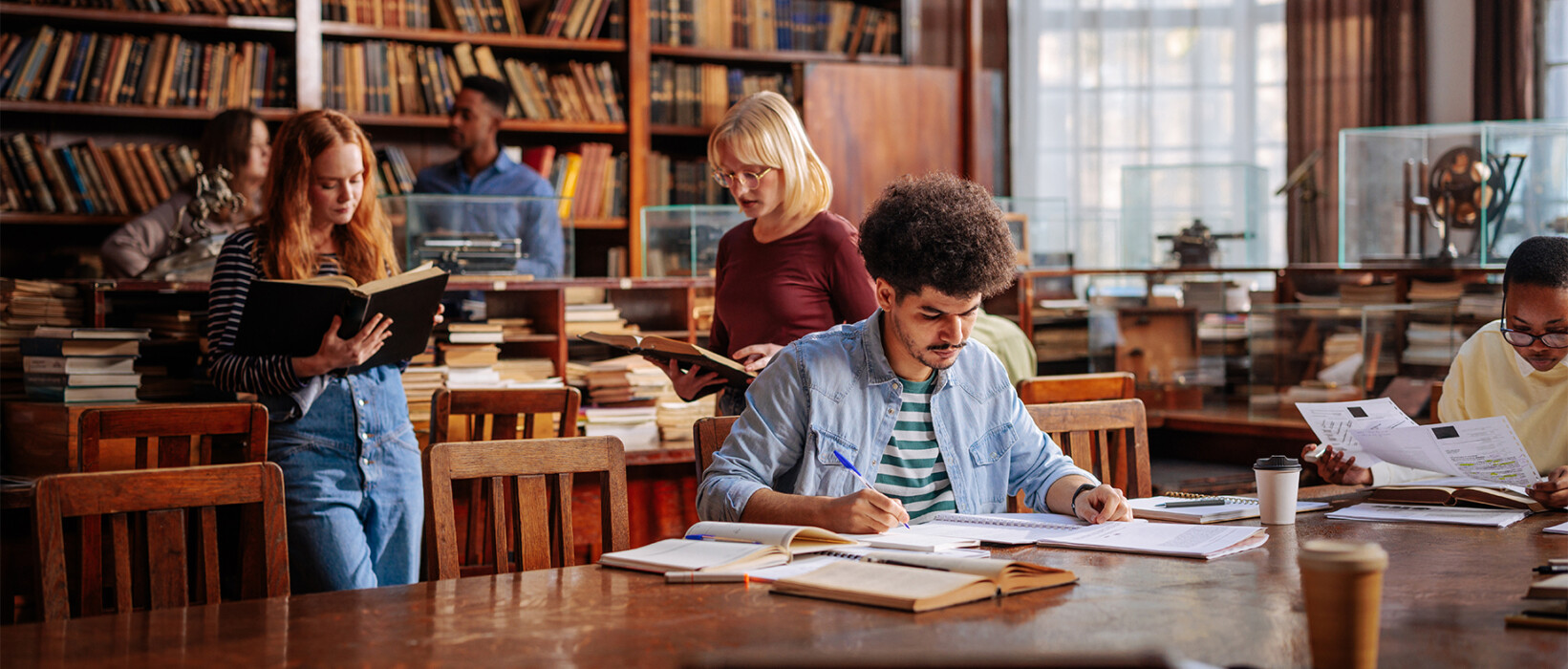 Students studying and reading in a library.